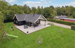 une petite maison avec une terrasse et une aire de jeux dans l'établissement 3 Bedroom Amazing Home In Silkeborg, à Silkeborg