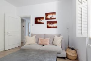 een witte woonkamer met een grijze bank bij Cozy and bright 1 bedroom apt in Knightsbridge in Londen