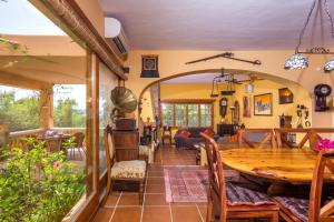 sala de estar con mesa de madera y sillas en Villa de Montaña gran piscina, en Sant Jordi