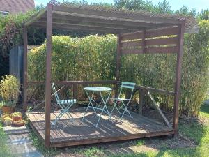 a wooden deck with a table and chairs on it at Belle maison - 5 chambres 4 sdb - proche circuit et pôle européen du cheval - idéal groupes & familles in Champagné