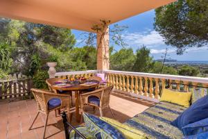 patio con mesa y sillas en el balcón en Villa de Montaña gran piscina, en Sant Jordi