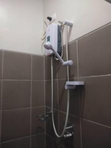 um chuveiro na casa de banho com um secador de cabelo na parede em Comfy Studio near Shaw MRT EDSA w/ Wi-Fi & Netflix em Manila