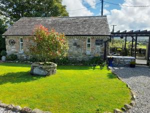 une vieille maison en pierre avec un arbre dans la cour dans l'établissement The Crossing, Barn, R95TH5C, à Ballyling