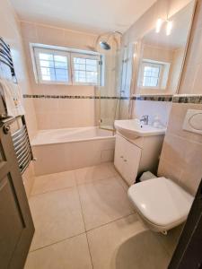 a bathroom with a toilet and a sink and a tub at Villa Nature entre Paris et Versailles in Marnes-la-Coquette