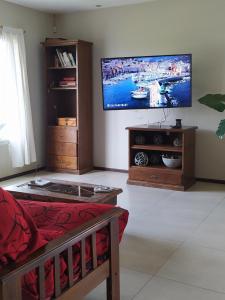 Una sala de estar con un televisor de pantalla plana en la pared. en La Casa de Vero en Acantilados, en Mar del Plata