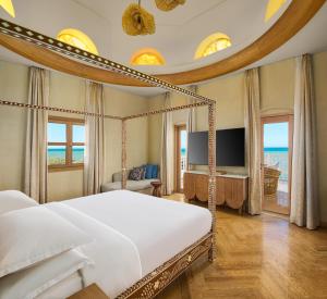 a bedroom with a large bed and a tv at Sheraton Miramar Resort El Gouna in Hurghada