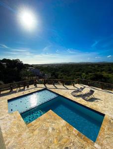a swimming pool with a view of the countryside at Pousada Preciosa in Búzios