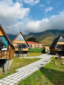 a group of houses with mountains in the background at Guesthouse Elli & Cottages in Kazbegi
