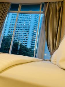 Schlafzimmer mit Blick auf ein großes Fenster in der Unterkunft Vortex suites klcc by Yashrib in Kuala Lumpur