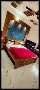 um quarto com uma cama de madeira e um cobertor vermelho em Rock Lake Villa em Vagamon