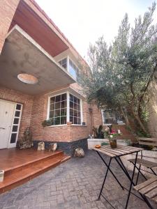 a brick house with a bench and a table at Casa Rural Goñi in Cabañas de Ebro