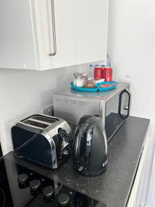 eine Küchentheke mit einem Toaster, einem Backofen und einem Toaster in der Unterkunft Modern Comfy One Bed Apartment - Free Parking in Glasgow