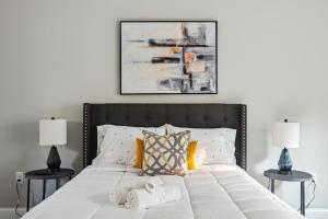 um quarto com uma grande cama branca e duas mesas em Suite Serenity 12Min from Uptown & Spectrum Ctr em Charlotte