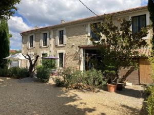 a stone house with a yard in front of it at Les lofts in LʼIsle-sur-la-Sorgue