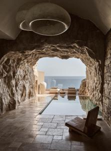 a room with a pool and a stone wall at Acro Suites - A Wellbeing Resort in Agia Pelagia