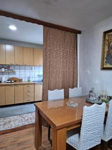 uma cozinha e sala de jantar com uma mesa de madeira e cadeiras em Dijanin Konak em Zvornik