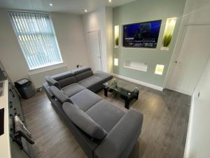 a living room with a couch and a tv at ENTIRE MODERN HOUSE in Elland