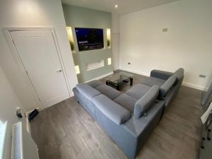 1 sofá grande en una sala de estar con TV en Entire Luxury House, en Elland