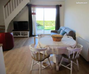 sala de estar con mesa, sillas y sofá en Cottage Lillstugan proche de la Baie de Somme, en Quesnoy-le-Montant