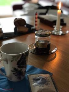 una taza de té y una vela sobre una mesa en Cottage Lillstugan proche de la Baie de Somme, en Quesnoy-le-Montant