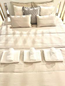 a white bed with four white towels on it at Apartament Pastel Room in Leśna