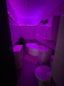 a purple bathroom with a toilet and a sink at Pinky studio in Dobroeşti