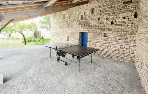 una mesa de ping pong dentro de una pared de ladrillo en Cozy Home In Loubign With Kitchenette, 