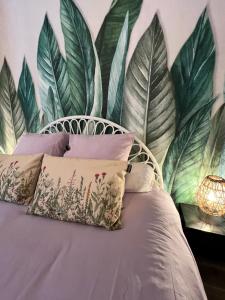 1 dormitorio con un mural de hojas en la pared en Appartement entre village et plages., en Saint-Cyr-sur-Mer