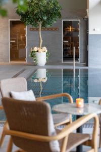 a table and chairs and a potted tree in a room at Starby Spa, Hotell & Konferens in Vadstena