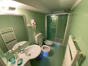 a green bathroom with a sink and a toilet at A o Soâ B&B in Savignone