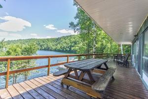 a wooden deck with a picnic table and a view of a lake at Nordika Lac St Pierre No. PERMIS CITQ: 298304 in Val des Monts