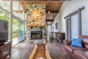 a living room with a stone fireplace and a couch at Nordika Lac St Pierre No. PERMIS CITQ: 298304 in Val des Monts