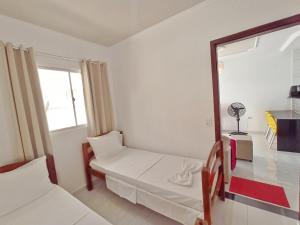 mały pokój z łóżkiem i lustrem w obiekcie Residencial Family House - CENTRO - Próximo à Praia w mieście São José da Coroa Grande
