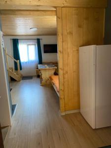 ein Zimmer mit Kühlschrank und ein Zimmer mit Schlafzimmer in der Unterkunft SKH RLS, 3 apartments, 5 bedrooms in Praid
