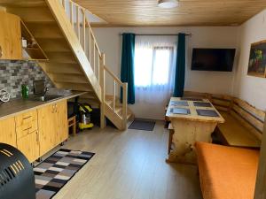 eine Küche mit einem Tisch und einer Treppe in einem Raum in der Unterkunft SKH RLS, 3 apartments, 5 bedrooms in Praid