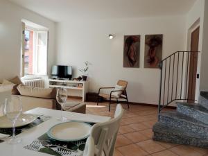 uma sala de estar com uma mesa e cadeiras e um sofá em La piazza al lago - A 40 metri dal lago em Mandello del Lario