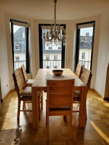 a dining room table with chairs and a chandelier at Komfort FeWo Stadt Mitte in Trier