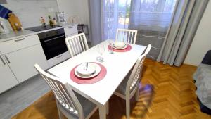 a kitchen with a white table with a plate of food on it at Apartment Tea 2 in Okrug Donji