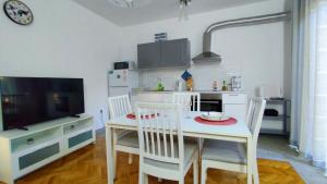 a kitchen with a table and chairs and a television at Apartment Tea 2 in Okrug Donji