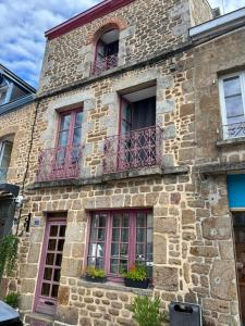 ein altes Steingebäude mit Fenstern und Balkonen in der Unterkunft Le Lys in Lassay