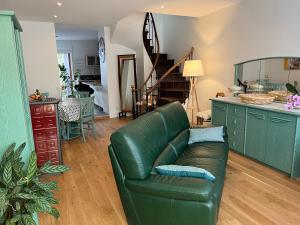 ein Wohnzimmer mit einer grünen Couch und einer Treppe in der Unterkunft Le Lys in Lassay
