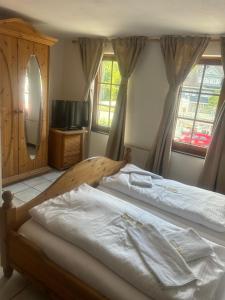 2 Betten in einem Schlafzimmer mit 2 Fenstern in der Unterkunft Gasthof zur Post in Siegen