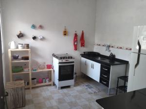 una piccola cucina con piano cottura e lavandino di Casinha Sossego na Praia a Caraguatatuba