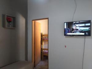 una camera con TV a parete e corridoio di Casinha Sossego na Praia a Caraguatatuba
