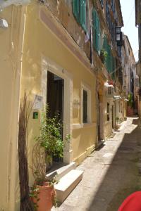 a narrow alley with buildings and potted plants at DePaolis Corfu Town Apartment in Corfu Town