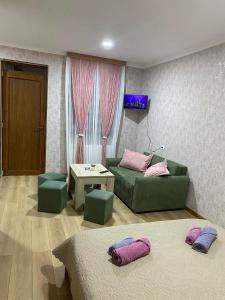 a living room with two beds and a couch and a table at Guest house BORJOMULA in Borjomi