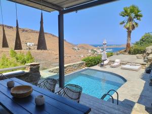a swimming pool with a table and chairs and a patio at Kydippi Kea Villa in Korissia