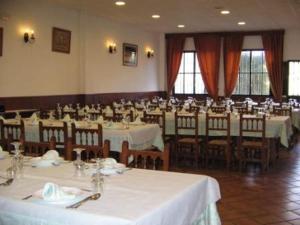 a large room with tables and chairs with white table cloth at El Aceitón in Cortegana