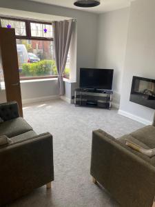 a living room with two couches and a flat screen tv at Huddersfield 2 bedroom house in Huddersfield