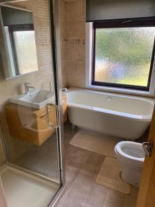 ein Badezimmer mit einer Badewanne, einem Waschbecken und einem WC in der Unterkunft Huddersfield 2 bedroom house in Huddersfield